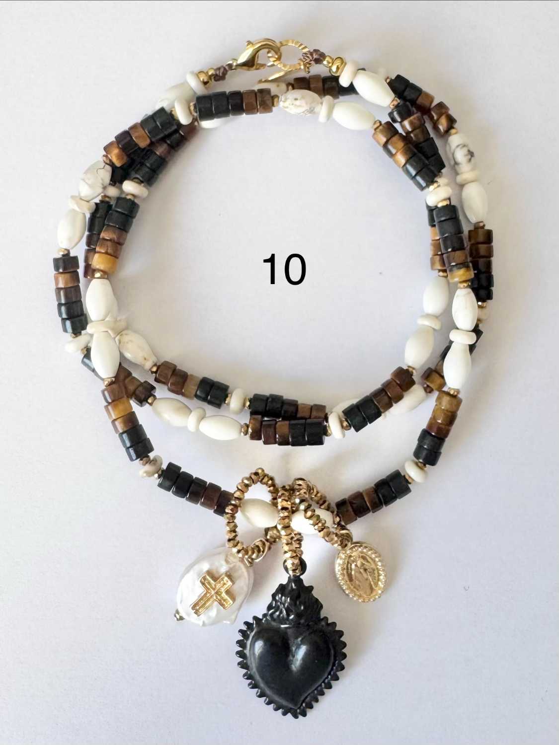 NOMAD-serie03-10-coeur-noir-sacre Collier NOMAD série 03 noir et ivoire avec coeur noir sacré, tête de mort ivoire et breloque dorée - Mademoiselle Oups