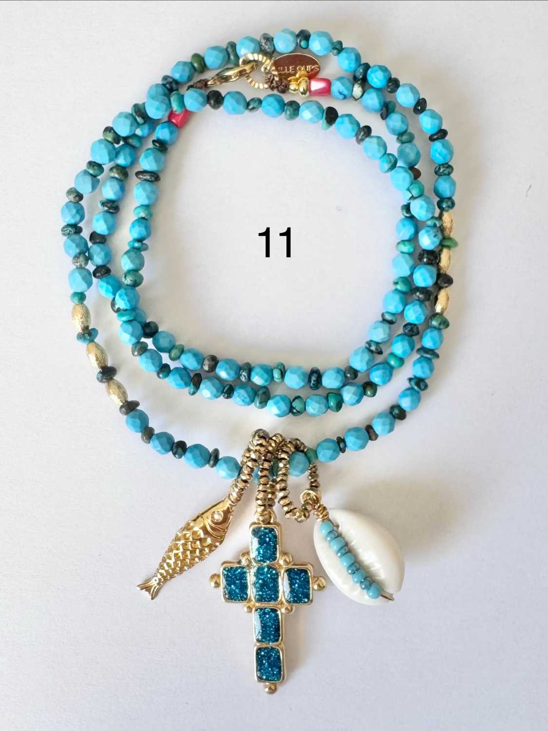 NOMAD-serie03-11-croix-bleu-turquoise-paillettes Collier NOMAD série 03 turquoise vif avec croix émaillée en turquoise pailletée, poisson doré et caurie - fabrication française Mademoiselle Oups