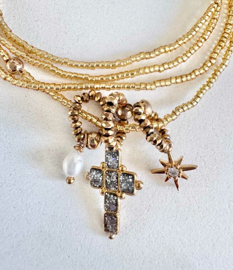 Détails du collier ICON 04 Mademoiselle Oups, collier doré avec croix émaillée de paillettes argentées, perle de culture et étoile en strass