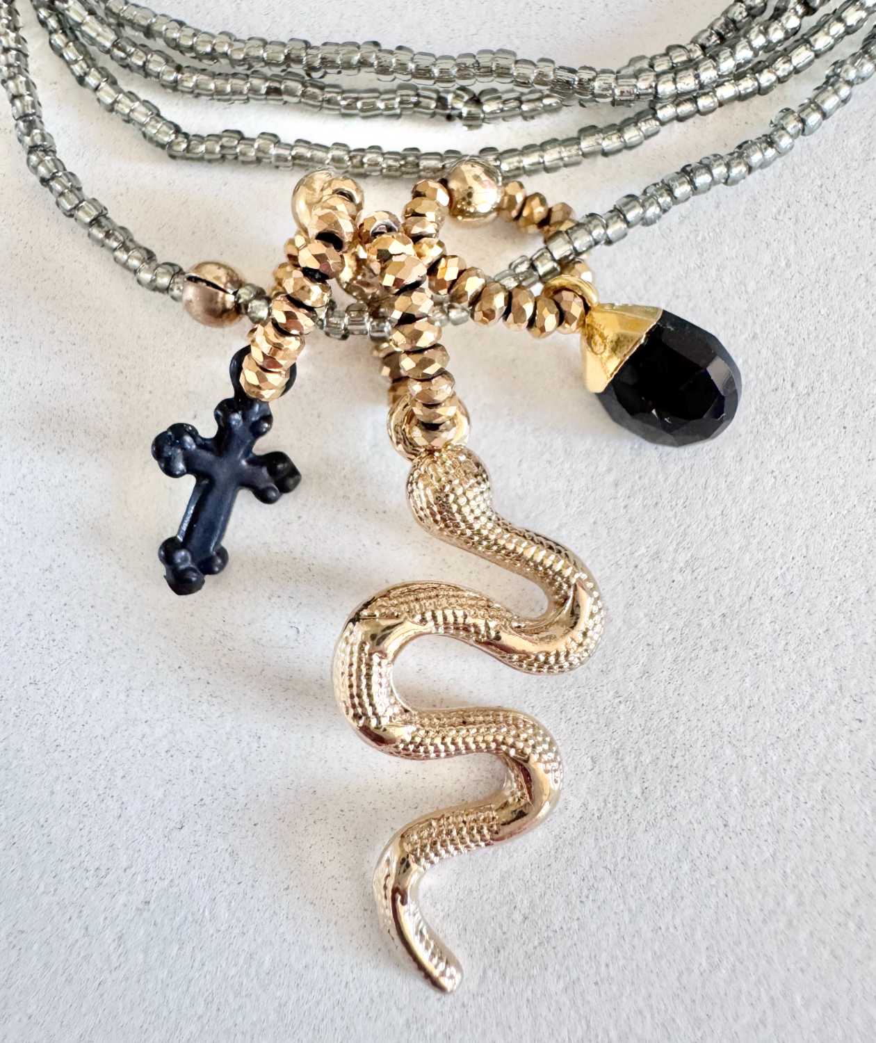 ICON-06-collier-serpent-breloques-noires-details Détails du collier ICON 06 Mademoiselle Oups, collier gris avec serpent doré, croix noire et pampille noire en onyx facetté