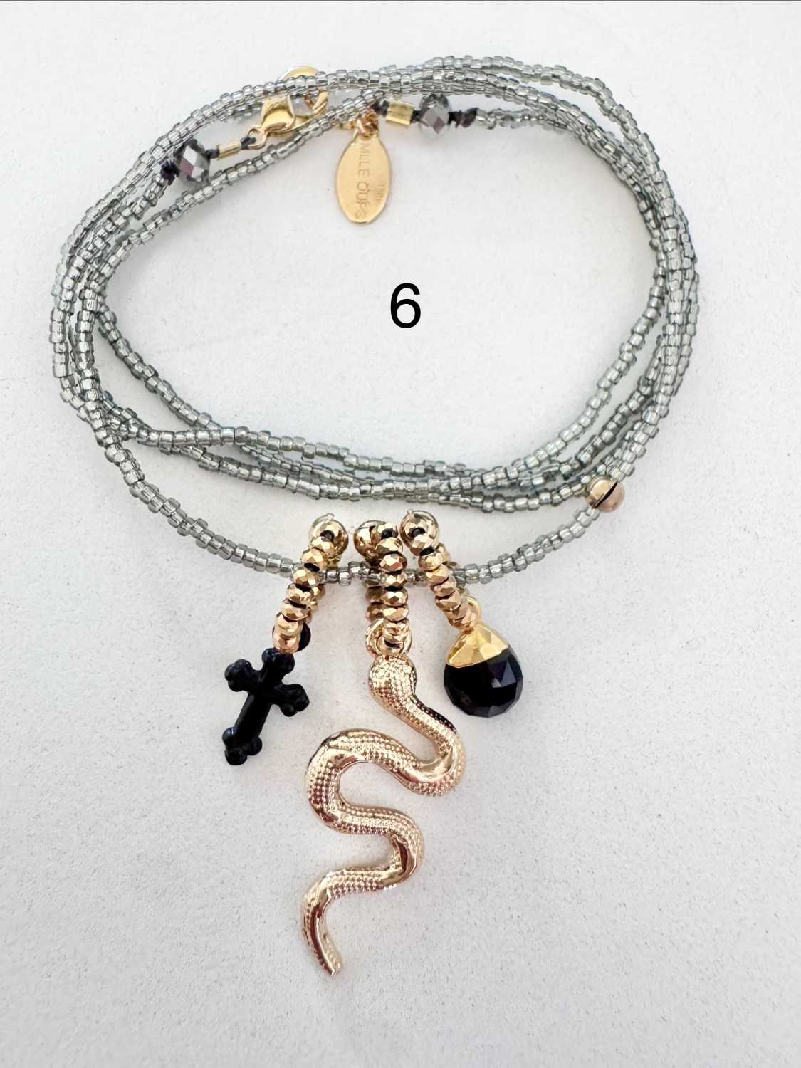 ICON-06-collier-serpent-breloques-noires Collier ICON 06 Mademoiselle Oups, collier gris avec serpent doré, croix noire et pampille noire en onyx facetté