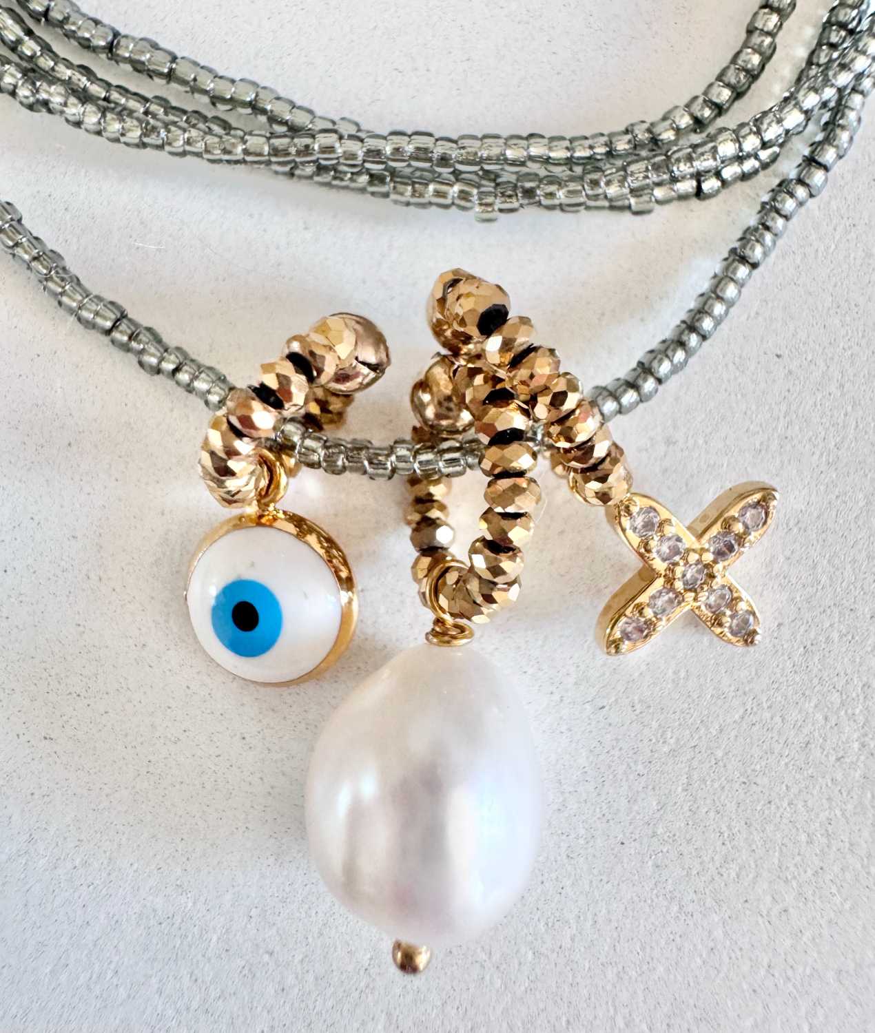 ICON-07-collier-croix-oeil-perle-de-culture-details Détails du collier ICON 07 Mademoiselle Oups, collier gris avec croix carrée en strass, grosse perle de culture et œil grec protecteur