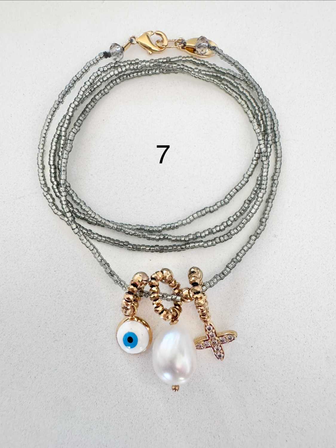 ICON-07-collier-croix-oeil-perle-de-culture Collier ICON 07 Mademoiselle Oups, collier gris avec croix carrée en strass, grosse perle de culture et œil grec protecteur