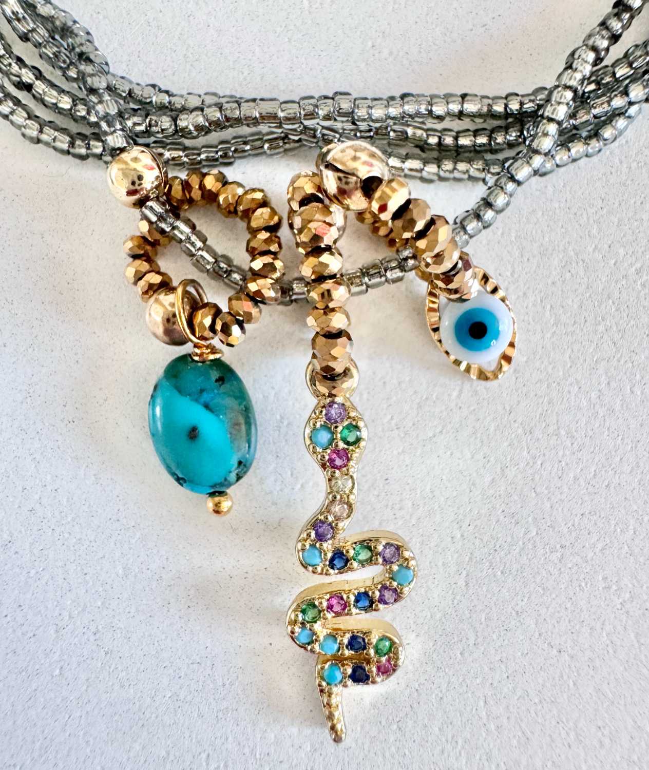 ICON-08-collier-serpent-turquoise-details Détails du collier ICON 08 Mademoiselle Oups, collier gris avec serpent serti de cristaux, œil protecteur et pierre en turquoise du Nevada
