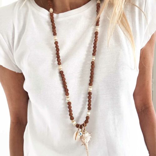 Sautoir SÉPIA en graines de Rudraksha, perles ivoire, coquillage naturel, œil protecteur et grand coquillage pendentif doré sur tshirt blanc porté en longueur – création artisanale Mademoiselle Oups