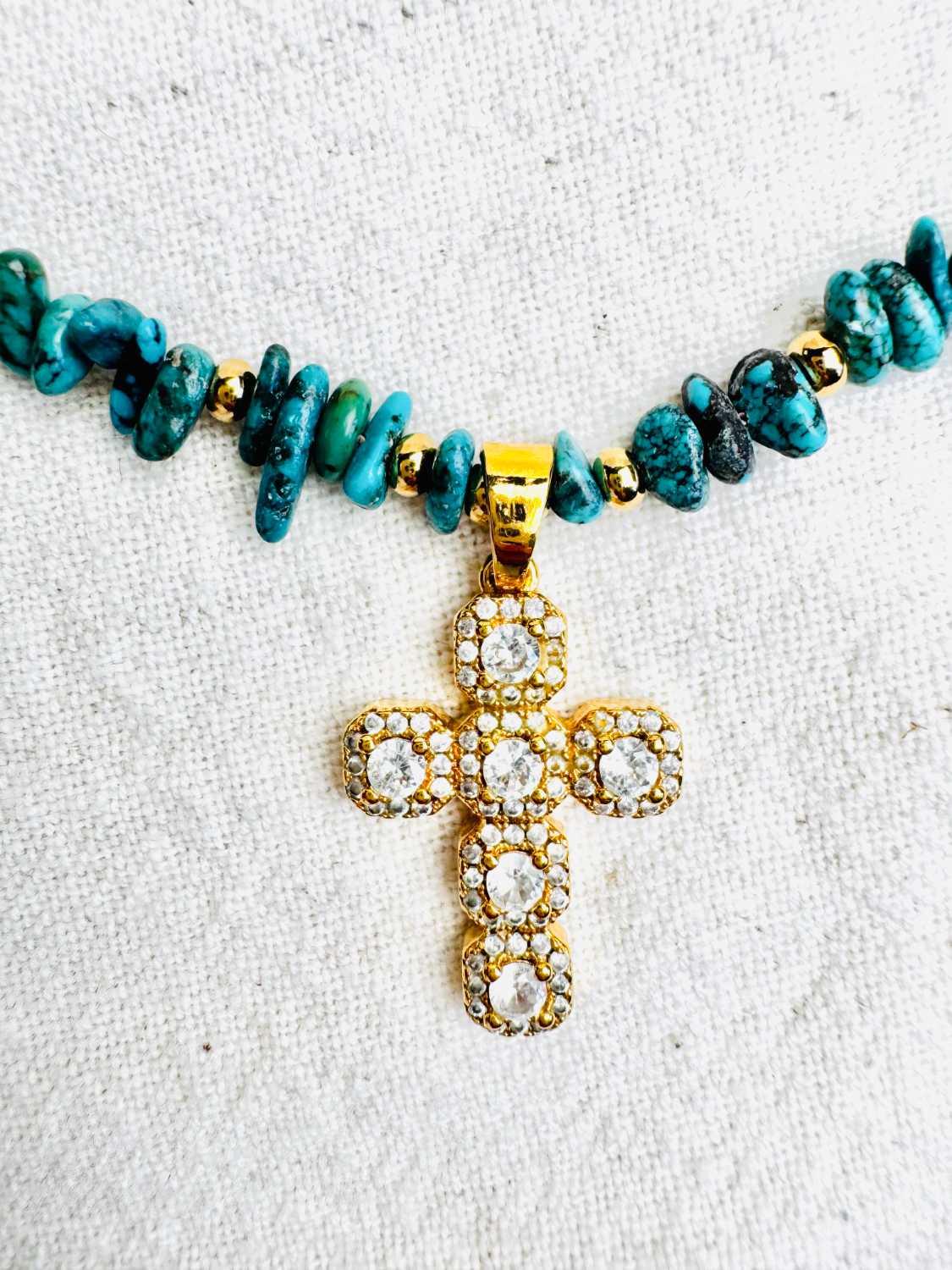INDIAN-SUMMER-collier-taos-detail-croix-strass-turquoises Collier TAOS en turquoise du Nevada avec pendentif croix dorée sertie de strass zoom sur la croix – collection Indian Summer Mademoiselle Oups